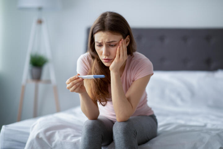 Giovane donna preoccupata attende il risultato del test di gravidanza dopo un rapporto non protetto