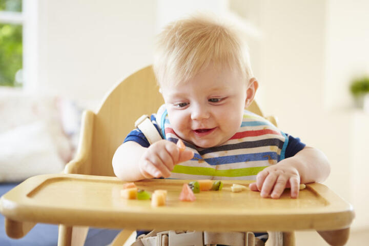 Bambino che impara a mangiare il cibo a pezzetti