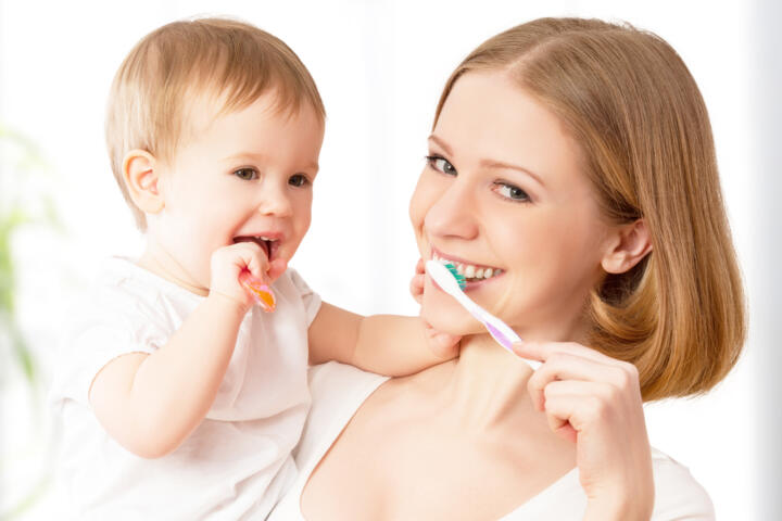 Mamma e bimba spazzolano i denti insieme