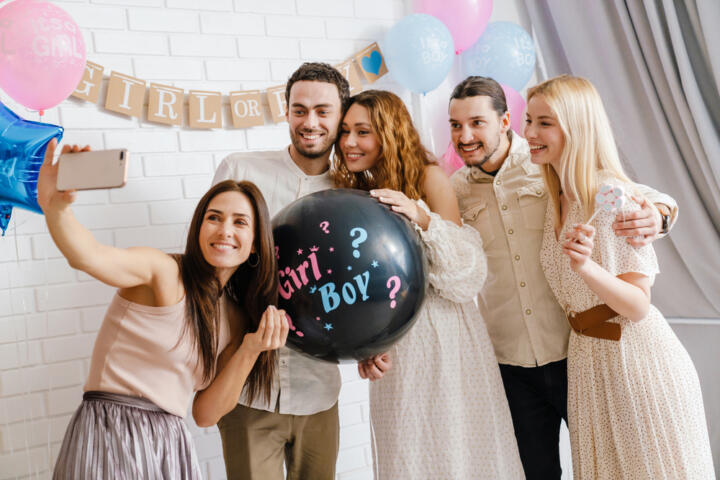 Immagine di futuri genitori e amici che festeggiano insieme il Gender Reveal Party