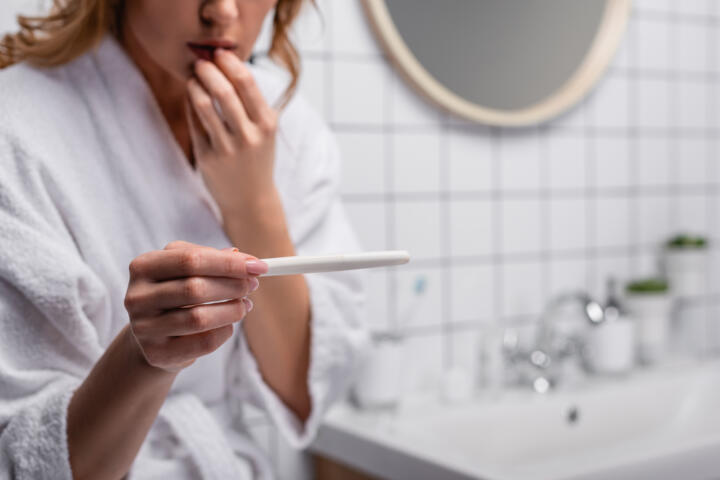 Cistite prima del ciclo gravidanza? Una donna esegue il test per confermare il concepimento.