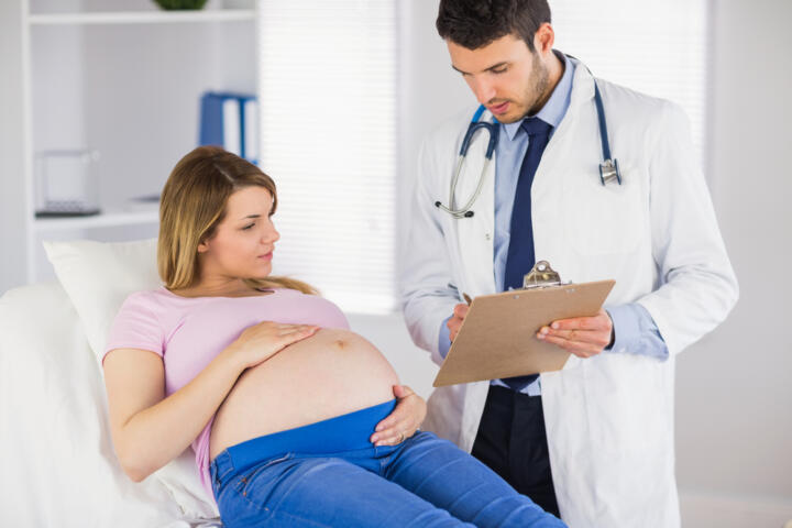 Ginecologo spiega a una giovane donna incinta i risultati del tampone per la ricerca dello streptococco in gravidanza