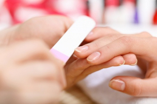 Estetista esegue la manicure a una donna in gravidanza