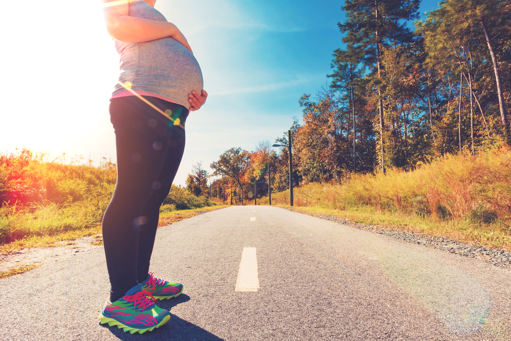 Camminare in gravidanza: immagine di donna incinta in tenuta sportiva per una passeggiata