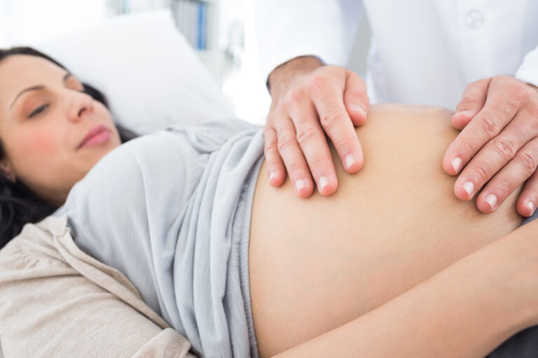 Medico visita una donna incinta prima di eseguire la manovra di rivolgimento